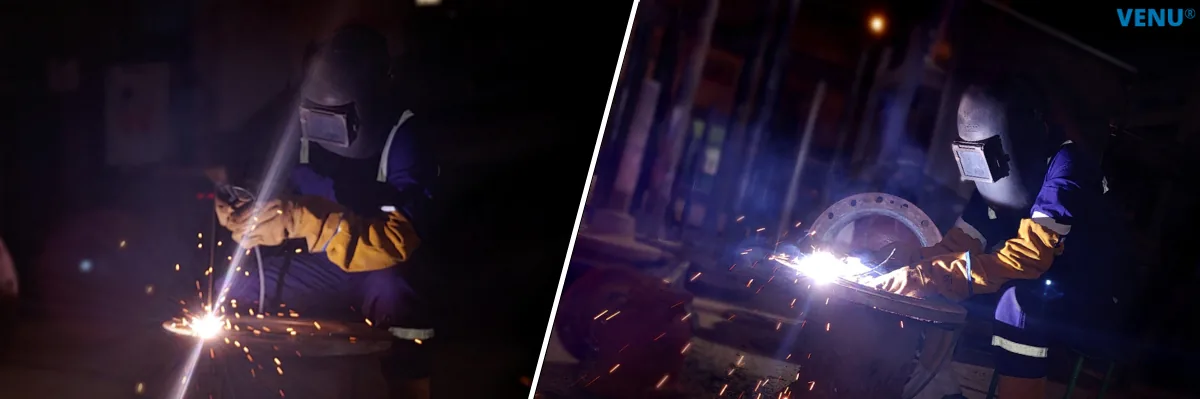 Two welders in leather gauntlets and face shields welding valve bodies, sparks flying.